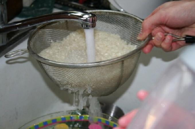 Nuplaukite ryžius į koštuvą patogus su tekančiu vandeniu.