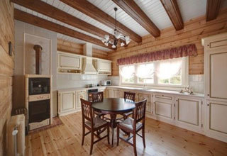 Provanso stiliaus virtuvė su medinėmis grindimis ir lubų sijomis.